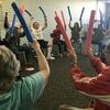 The Parkinsons exercise class practices arm raises with lengths of pool noodles.