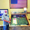 Vietnam Veteran Tom Center stands next to the flag he donated to College of the Ozarks.